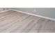 Close up of light wood-look flooring with white base trim at 4171 Whispering Forest Sw Ct, Lilburn, GA 30047