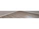 Close up of light wood-look flooring with white base trim at 4171 Whispering Forest Sw Ct, Lilburn, GA 30047