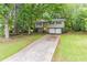 Split-level home with a bright yellow front door, attached two-car garage, and a long driveway at 4171 Whispering Forest Sw Ct, Lilburn, GA 30047