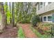 Landscaped yard featuring a pine needle path, trees, colorful azaleas, and lush greenery at 4171 Whispering Forest Sw Ct, Lilburn, GA 30047