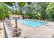 Outdoor swimming pool with chairs, umbrellas, changing house and diving board surrounded by mature trees at 4171 Whispering Forest Sw Ct, Lilburn, GA 30047