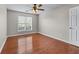 Bedroom with wood floors, ceiling fan, and a large window offering natural light at 4584 Brook Farms Dr, Duluth, GA 30096