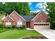 Charming brick home with manicured lawn, mature trees and attached two car garage, creating an inviting curb appeal at 4584 Brook Farms Dr, Duluth, GA 30096