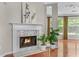 Close up of fireplace in living room featuring hardwood floors, white trim, and abundant natural light at 4584 Brook Farms Dr, Duluth, GA 30096