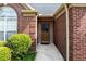 Inviting front entrance featuring a brown door, brick surround, and well-maintained landscaping at 4584 Brook Farms Dr, Duluth, GA 30096