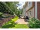 Beautiful outdoor space featuring stone patio, lush landscaping, retaining wall and mature trees at 5370 Newport Bay Psge, Alpharetta, GA 30005