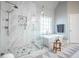 Luxury bathroom featuring a glass-enclosed shower, soaking tub, and decorative tile flooring at 5370 Newport Bay Psge, Alpharetta, GA 30005