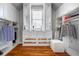 This spacious walk-in closet features custom shelving, drawers, mirrors, and a comfortable ottoman at 5370 Newport Bay Psge, Alpharetta, GA 30005