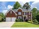 Charming two-story red brick home with well-manicured lawn, two-car garage and manicured shrubbery at 5370 Newport Bay Psge, Alpharetta, GA 30005