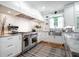 Gourmet kitchen with stainless steel appliances, stone countertops, white cabinets, and hardwood flooring at 5370 Newport Bay Psge, Alpharetta, GA 30005