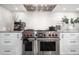 Close-up of the gourmet kitchen featuring stainless steel appliances and stone countertops with subway tile backsplash at 5370 Newport Bay Psge, Alpharetta, GA 30005