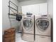 This laundry room is complete with washer, dryer, storage cabinets, and a convenient clothes rack at 5370 Newport Bay Psge, Alpharetta, GA 30005