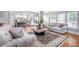 Bright living room with hardwood floors, neutral furnishings, and lots of natural light from many windows at 5370 Newport Bay Psge, Alpharetta, GA 30005