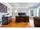 Bright home office with hardwood floors, large desk, and ample natural light at 5370 Newport Bay Psge, Alpharetta, GA 30005