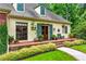 Charming home with a manicured lawn, lush greenery, and a welcoming brick-lined porch to the front door at 5945 W Andechs Smt, Johns Creek, GA 30097