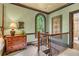 Hallway with wooden trim, arched window and staircase access with wood and wrought iron handrail at 5945 W Andechs Smt, Johns Creek, GA 30097