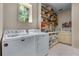 Well-equipped laundry room featuring modern appliances, ample counter space, and shelving for organized storage at 5945 W Andechs Smt, Johns Creek, GA 30097
