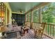 Cozy screened porch featuring comfortable seating and wooded backyard views at 5945 W Andechs Smt, Johns Creek, GA 30097