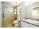 Modern bathroom with glass shower and stone pebble flooring, large sink and updated fixtures at 1583 Rogers Crossing Dr, Lithonia, GA 30058