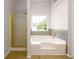 Bright bathroom featuring a bathtub with mosaic tile backsplash and separate gold framed glass shower at 1583 Rogers Crossing Dr, Lithonia, GA 30058