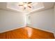 Bright bedroom featuring hardwood floors and a tray ceiling at 1583 Rogers Crossing Dr, Lithonia, GA 30058