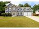 Charming two-story home featuring stone accents, a well-maintained lawn, and an attached two-car garage at 1583 Rogers Crossing Dr, Lithonia, GA 30058