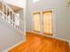 Bright foyer featuring hardwood floors, staircase with white railing and double doors at 1583 Rogers Crossing Dr, Lithonia, GA 30058