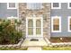Close-up of a home's stone facade entrance with elegant double doors and manicured landscaping at 1583 Rogers Crossing Dr, Lithonia, GA 30058