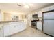 Open kitchen with stainless appliances, white cabinets and tile flooring at 1583 Rogers Crossing Dr, Lithonia, GA 30058