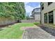 View of the backyard with a brick patio, grass, wooden fence, and home exterior at 1839 Kent Ave, Atlanta, GA 30338