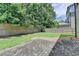 View of the backyard with a brick patio, grass, wooden fence, and mature trees at 1839 Kent Ave, Atlanta, GA 30338