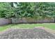 View of the backyard with a brick patio, grass, wooden fence, and mature trees at 1839 Kent Ave, Atlanta, GA 30338