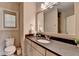 Clean bathroom featuring a single sink vanity, a toilet, and a mirror, next to the glass door shower at 1839 Kent Ave, Atlanta, GA 30338