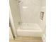 Bathroom featuring a white bathtub with shower head and marble tiling at 323 W Claiborne Ct, Marietta, GA 30066