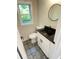 Chic powder room with black countertop, black accents, and a window providing natural light at 323 W Claiborne Ct, Marietta, GA 30066