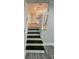 Staircase featuring dark wood stairs and white railings, leading to an open-concept kitchen at 323 W Claiborne Ct, Marietta, GA 30066