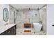 Modern bathroom features a glass enclosed shower, standalone tub, and sleek vanity with marble countertop at 7590 Chaparral Dr, Atlanta, GA 30350