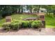 Chaparral Estates brick entrance with manicured landscaping and a glimpse of a beautiful home on the hillside at 7590 Chaparral Dr, Atlanta, GA 30350