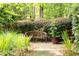 Stone walkway with a wooden bench surrounded by lush greenery and garden at 7590 Chaparral Dr, Atlanta, GA 30350