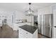 Large kitchen with stainless refrigerator, black countertops, white cabinets and kitchen island at 7590 Chaparral Dr, Atlanta, GA 30350