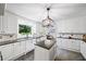 Spacious kitchen featuring white cabinets, black countertops, stainless appliances and center island at 7590 Chaparral Dr, Atlanta, GA 30350