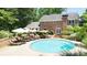 Beautiful backyard pool with lounge chairs, umbrellas and brick house backdrop at 7590 Chaparral Dr, Atlanta, GA 30350