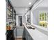 Elegant wet bar with marble counters, mirrored backsplash, and glass shelving at 7590 Chaparral Dr, Atlanta, GA 30350
