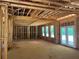 View of living room under construction, exposed framing with door to the outside and rough cut floors at 95 Cambridge Dr, Covington, GA 30014