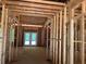 Living room under construction showing exposed wood framing and a set of french doors at 95 Cambridge Dr, Covington, GA 30014