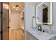 Modern bathroom features a sleek vanity with stone countertop and illuminated mirror, plus a walk in closet at 136 Beutell St, Norcross, GA 30071