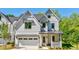 Charming two-story home with white siding, a well-manicured lawn, and an attached garage with metal awnings at 136 Beutell St, Norcross, GA 30071
