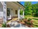 Inviting front porch with white columns, wood decking, and landscaping that adds to the home's curb appeal at 136 Beutell St, Norcross, GA 30071