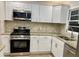 This kitchen features stainless steel appliances, granite countertops, and ample white cabinetry at 1607 Hillview, Jonesboro, GA 30236