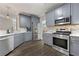 Spacious eat-in kitchen featuring stainless steel appliances, gray cabinets, and hardwood floors at 2994 Meadow Church Rd, Suwanee, GA 30024
